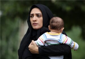 مینا ساداتی با چادر و بچه ای در بغلش